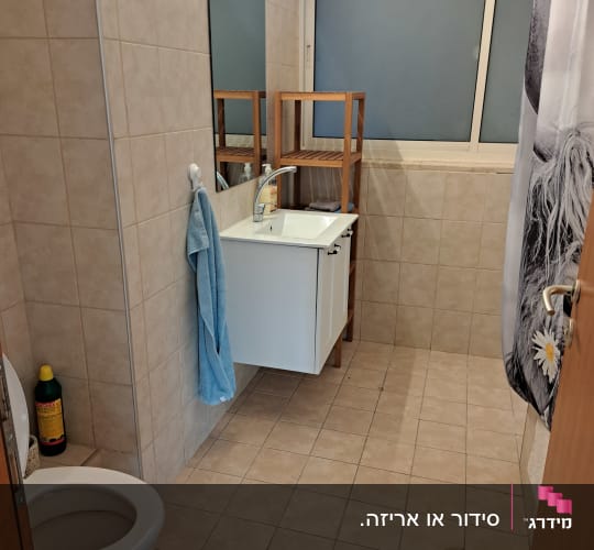 חדר אמבטיה מסודר עם כיור ומראה